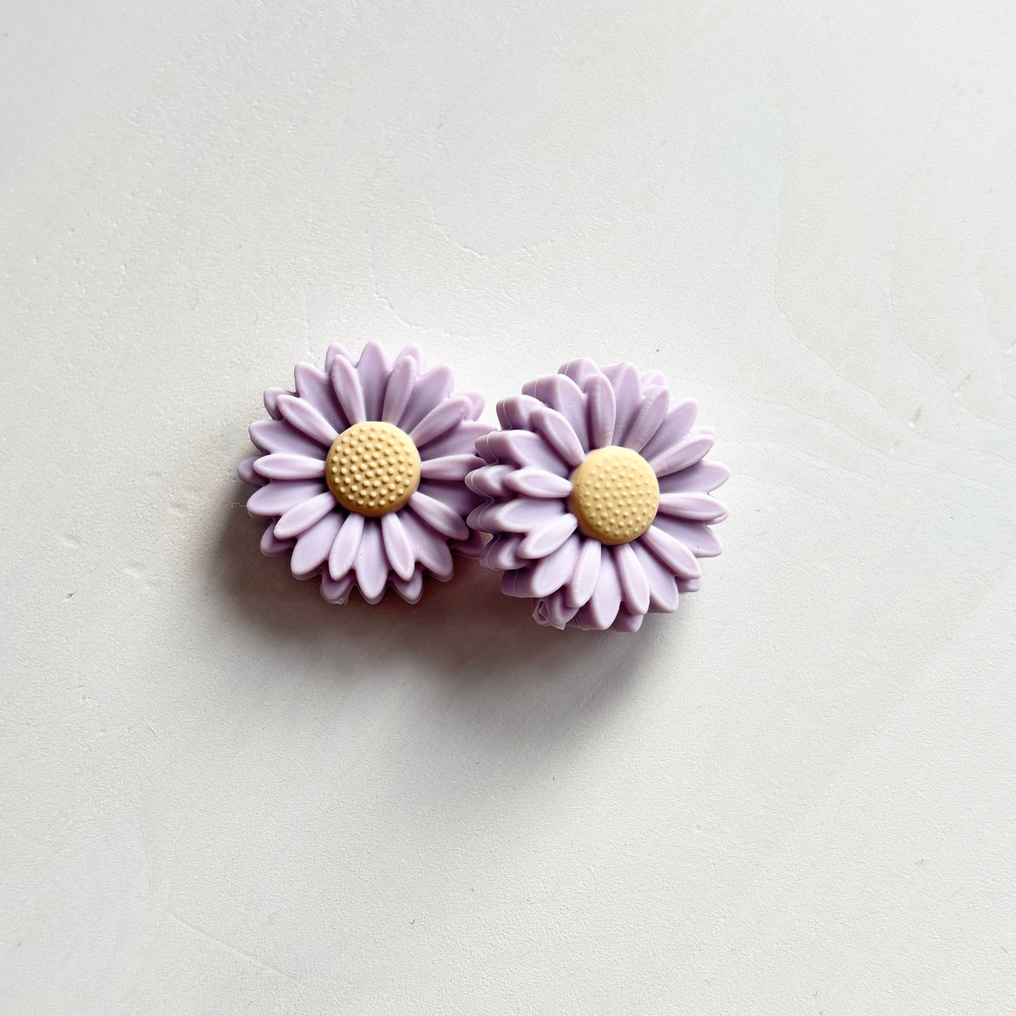 Lilat kukka puikkostopparit. Auttavat pitämään silmukat puikoilla.