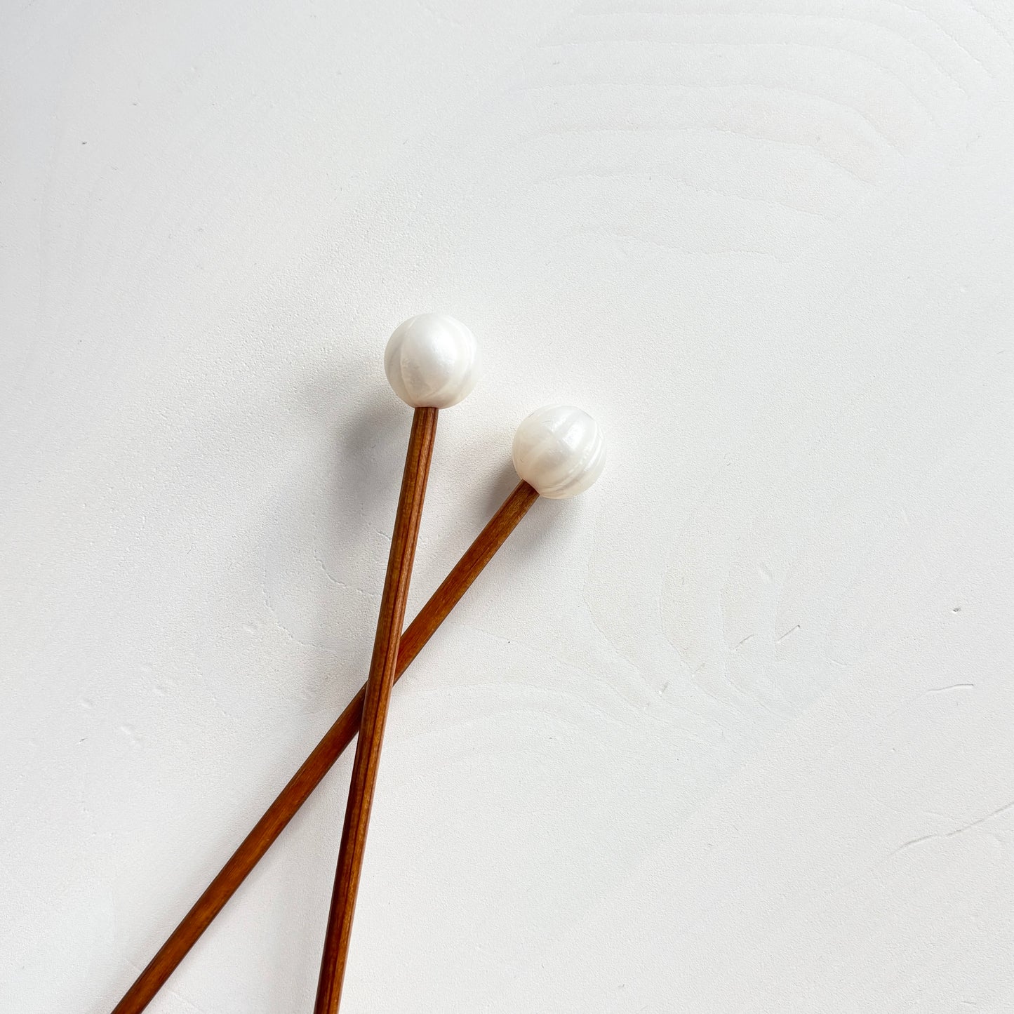 Helmiäisvalkoiset pallo puikkostopparit. Auttavat pitämään silmukat puikoilla.