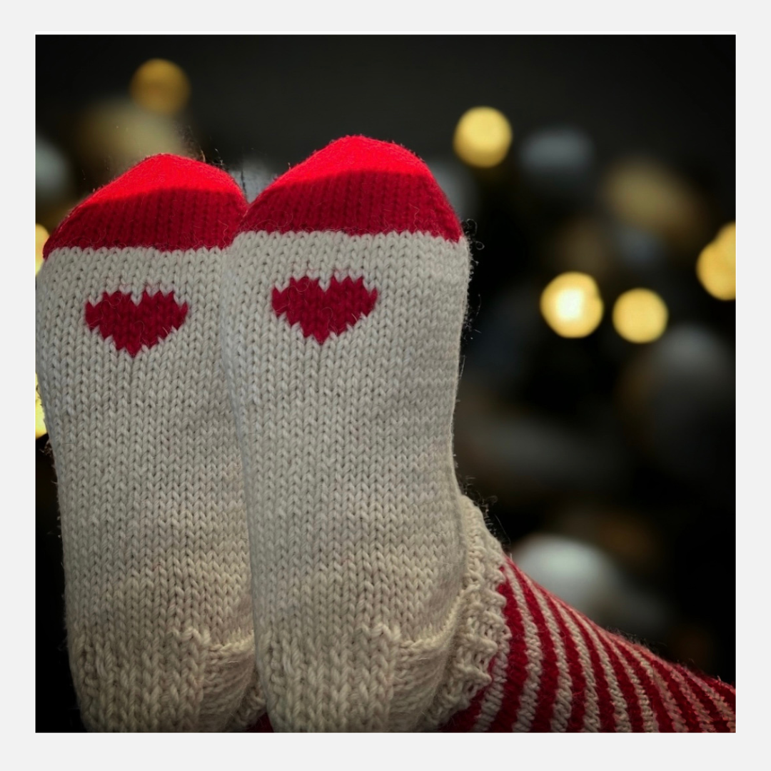 Candy  Cane-kirjoneulevillasukat. Puna-valkoista vinoraitaa. Jalkapohjassa pieni sydän. Neuleohje saatavilla NordicKitty verkkokaupassa.